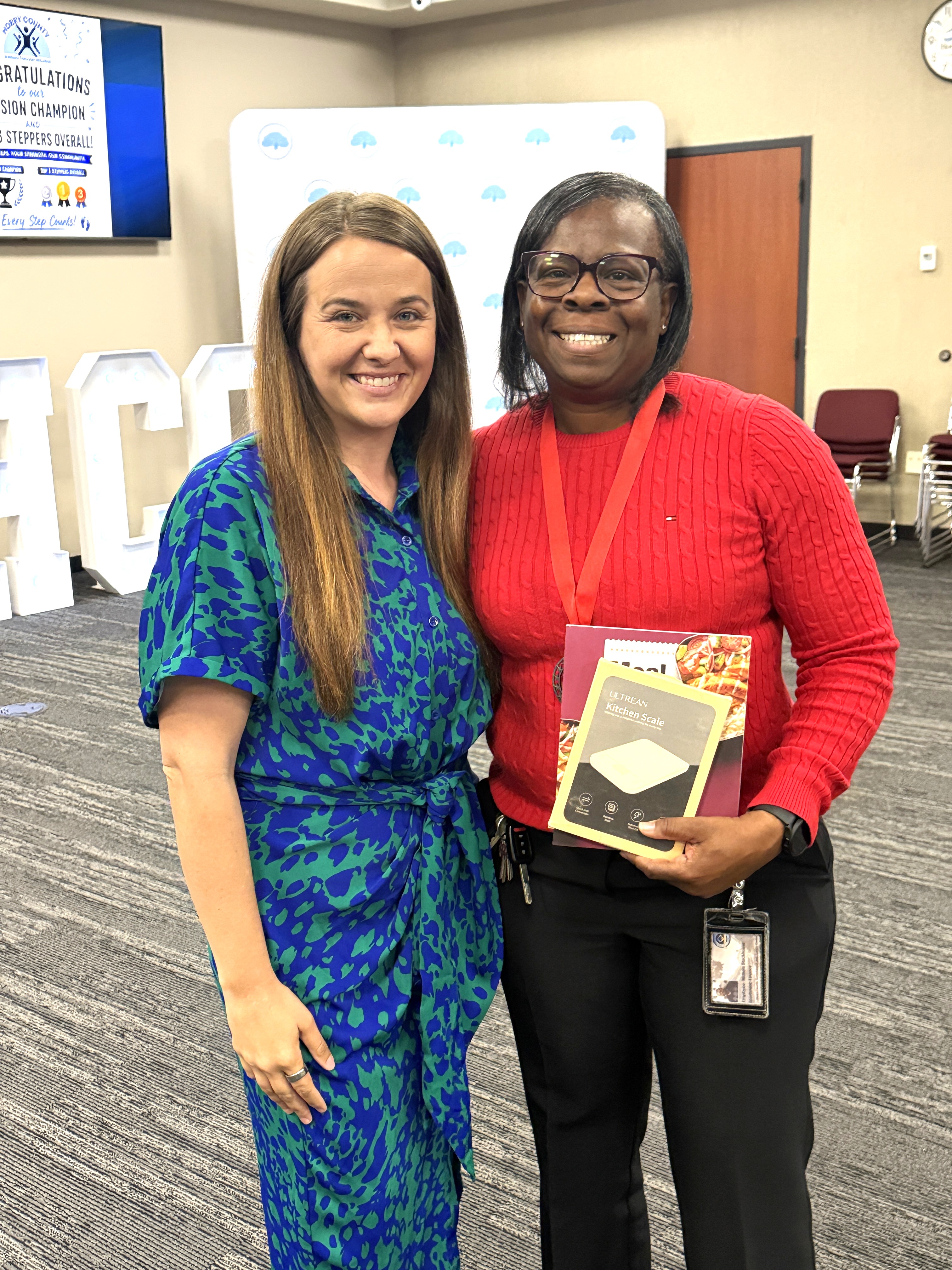 Photo of second place individual stepper, Nikki, posing for photo with Assistant County Administrator Shannon Todd, along with her medal